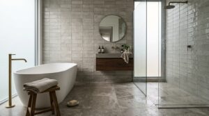 Modern bathroom with freestanding tub, floating vanity, walk-in shower, and textured tiles – shown via Badplaner Online.