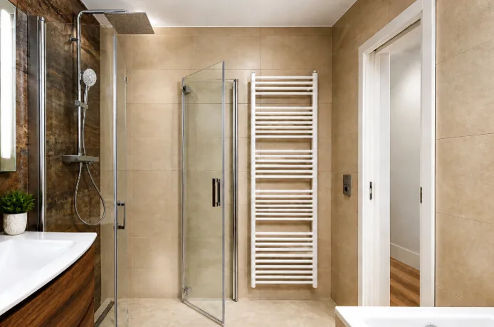 Moderne Glasdusche installiert in einem eleganten Badezimmer mit beigefarbenen Fliesen