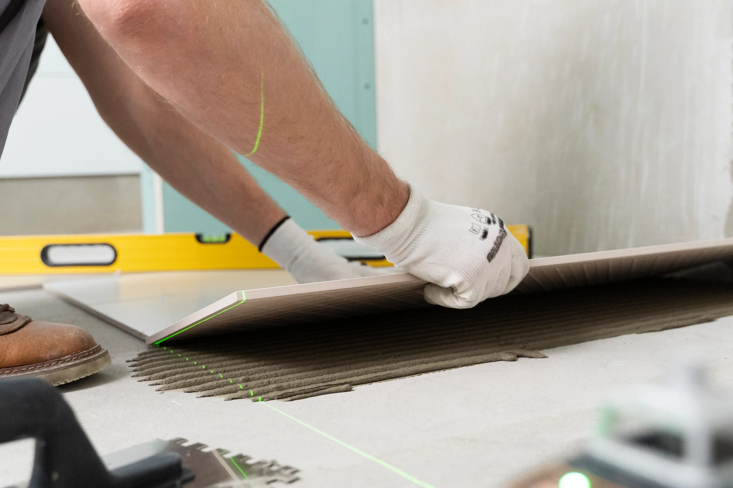 Professioneller Handwerker beim Fliesen Verlegen Lassen in modernem Wohnraum mit präzisem Ausrichten