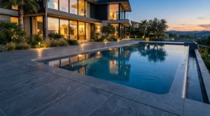 Dunkle Großformatfliesen umgeben modernen Infinitypool am Haus für Pool Fliesen