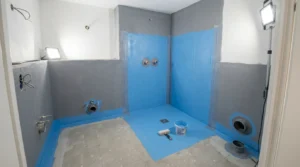 Blaue Verbundabdichtung schützt Dusche und Rohranschlüsse bei der Sanitärinstallation Badneubau